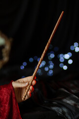 A magician's hand holds a carved magic wand