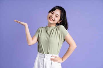 Portrait of beautiful Asian girl posing on purple background