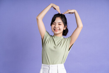 Portrait of beautiful Asian girl posing on purple background