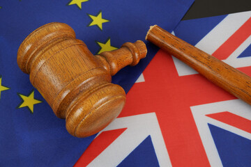 UK and EU collaboration, relationship problems concept. Broken judge gavel on UK and EU flags.