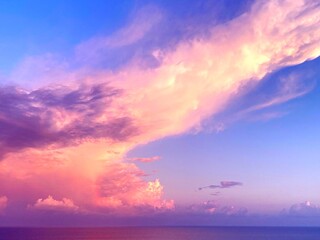 Sunset fluffy clouds in the sky over sea.