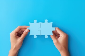 Concept of business,hands holding a jigsaw puzzle on pastel blue background, in blue  colors,puzzles converge