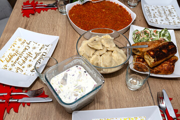 A table set for Christmas dinner in Poland, visible dumplings, croquettes and herrings in cream.