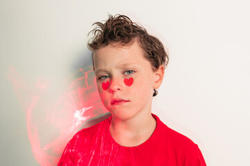 Calm boy with heart stickers on cheeks and abstract red patterns