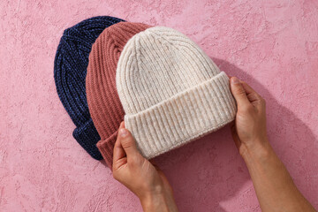 Multicolored warm hats on a pink background