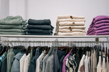 Color coordinated apparel displayed neatly in clothing store.
