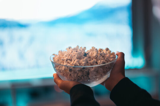 Unrecognizable person holding popcorn bowl in hands