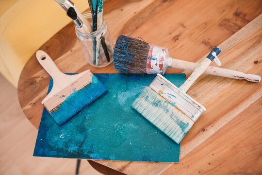 Palette with paintbrushes on wooden table