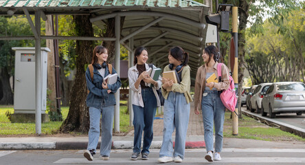 Obraz premium Happy young student chat with each other after class. Guy and girls wear casual clothes to study. Lifestyle concept, sincere emotions