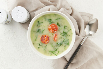 Portuguese style soup Caldo Verde with bread on white background close up