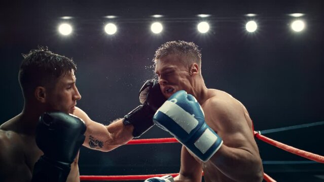 Cinematic Footage with a Speed Ramp Super Slow Motion Effect. Two Professional Boxers Fight in a Ring. Boxer Ducking to Avoiding a Hit, Punching with a Hook to the Face, Rocking the Opponent