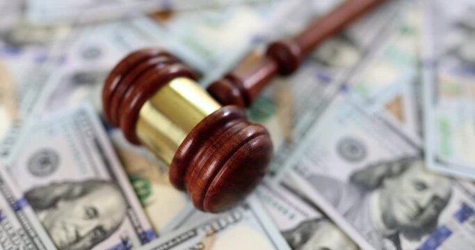 A hammer of a judge lies against a background of money, a closeup. Corruption concept in the judicial system