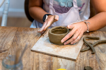 Obraz na płótnie Canvas Ceramic Workshop. Middle aged woman working on her new ceramic creation