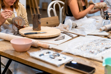 Fototapeta na wymiar Ceramic Workshop. Middle aged woman repairing pottery