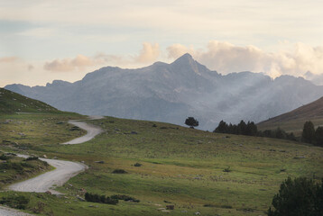 Paisaje de camino yendo hacia las monta&ntilde;as con el atardecer