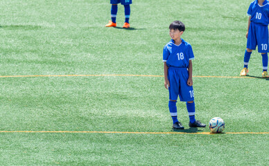 サッカーの試合をする小学生の男の子 © tatsushi