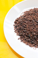 Black himalayan salt on yellow background.