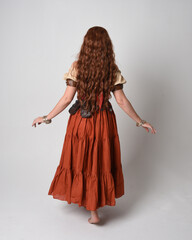 Full length portrait of beautiful red haired woman wearing a medieval maiden, fortune teller...
