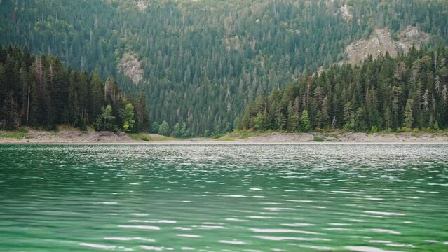 Static cinematic shot of a beautiful mountain lake with turquoise water on a sunny day