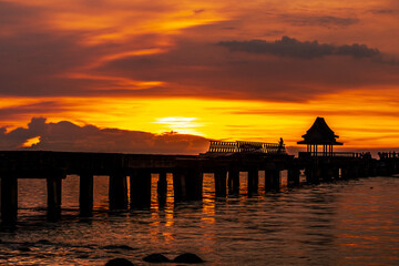 Obraz premium The background of the sea by the evening sea, with natural beauty (sea water, rocks, sky) and fishermen are fishing by the river bank, is a pleasure during travel.