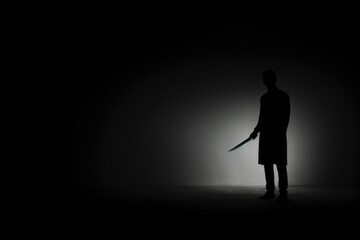 silhouette of a dangerous man holding knife. Copy space for text