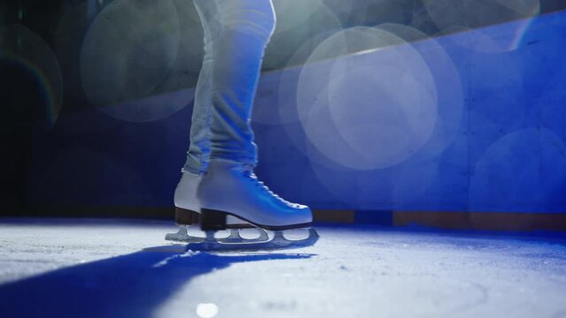 A close-up shot of a girl ice skate in a circle recorded in slow motion, blurred