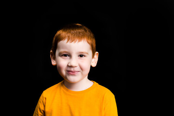 a boy with red hair smiles and laughs