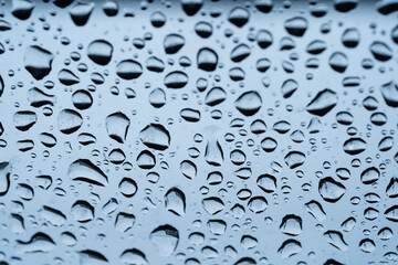 Rain drops cling to the car windshield, selective focus, soft focus.