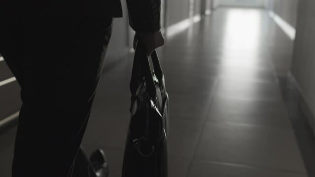 Selective focus close-up shot of leather briefcase in male hand