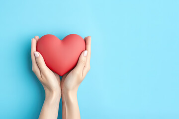 Obraz premium hand holds a heart love shape on a blue background with copy space