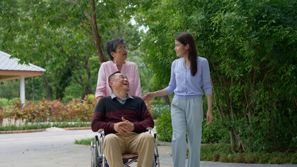 Fototapeta premium A daughter taking care of the patient in a wheelchair and talk with mom. Concept of happy retirement with care from a caregiver and Savings and senior health insurance, Happy family and retirement