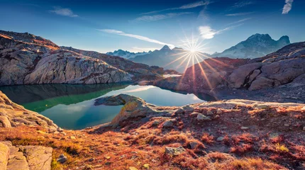 Fototapeten Sunny autumn scene of Lac Blanc lake with Mont Blanc (Monte Bianco) on background, Chamonix location. Astonishing morning view of Vallon de Berard Nature Preserve, Graian Alps, France, Europe. © Andrew Mayovskyy