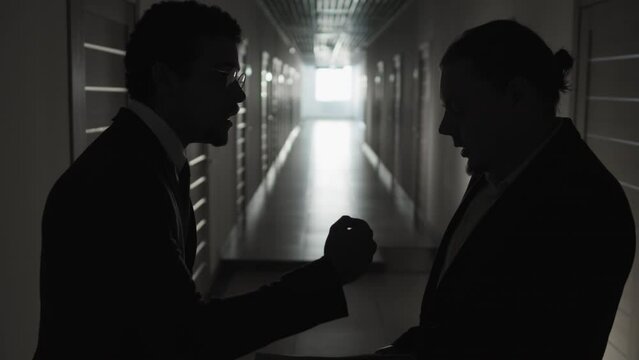 Medium shot of silhouettes of boss blaming for mistakes in documents his subordinate