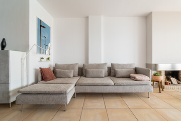 Large grey couch with cushions and plaid in home apartment