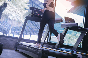 Fit young woman workout jogging in machine treadmill at fitness gym. Selected focus