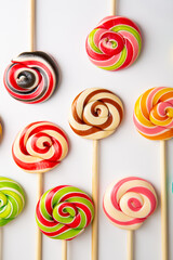 Fototapeta na wymiar Sweet lolli pop swirly candies on white surface food background