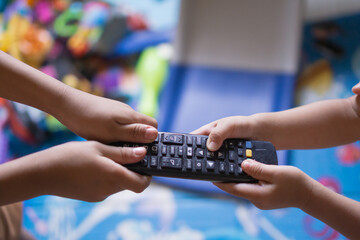 sibling fight over tv remote in a messy living room