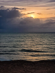 sunrise in the ocean with blue and orange sky with dramatic clouds seen from the cliff, at Pipa beach - Brazil