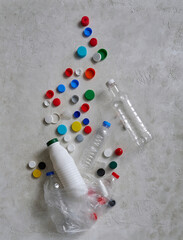 Plastic bottles and caps are on the green table, recycling waste concept.