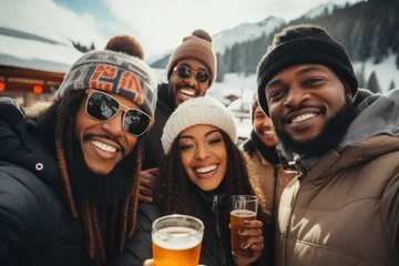 Muurstickers A happy and diverse group of young men and women, donned in winter attire, posing for a photo during a ski vacation in the mountains while enjoying alcoholic beverages and having a great time. © Creative Clicks