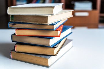 Stack of books, photographed closely, on white surface.
