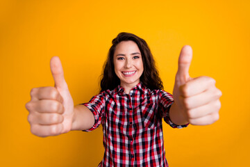 Photo of toothy beaming woman with wavy hairdo dressed checkered shirt showing thumbs up to you good job isolated on yellow background