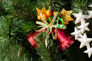 Red color bell decorate on green christmas treee background