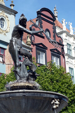 bronze statue of Tryton fountain in Gdansk Poland pigeon bird on head