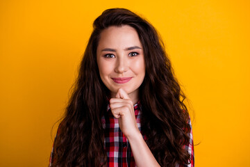 Photo of intelligent positive woman with wavy hairdo dressed checkered shirt hold hand on chin get idea isolated on yellow background