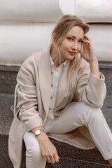 Fashion woman wearing beige coat on the street - obrazy, fototapety, plakaty