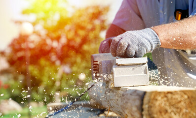 a carpenter works with an electric pipe on a sunny day