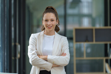 Portrait of a successful businesswoman inside the office, standing with arms crossed.
