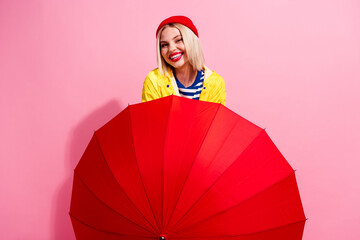 Photo of excited adorable lady wear raincoat walking under umbrella isolated pink color background