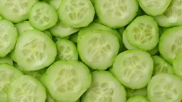 Cucumber slices top view, rotation. Background of chopped cucumber slices for cooking show, restaurant, cafe, fast food